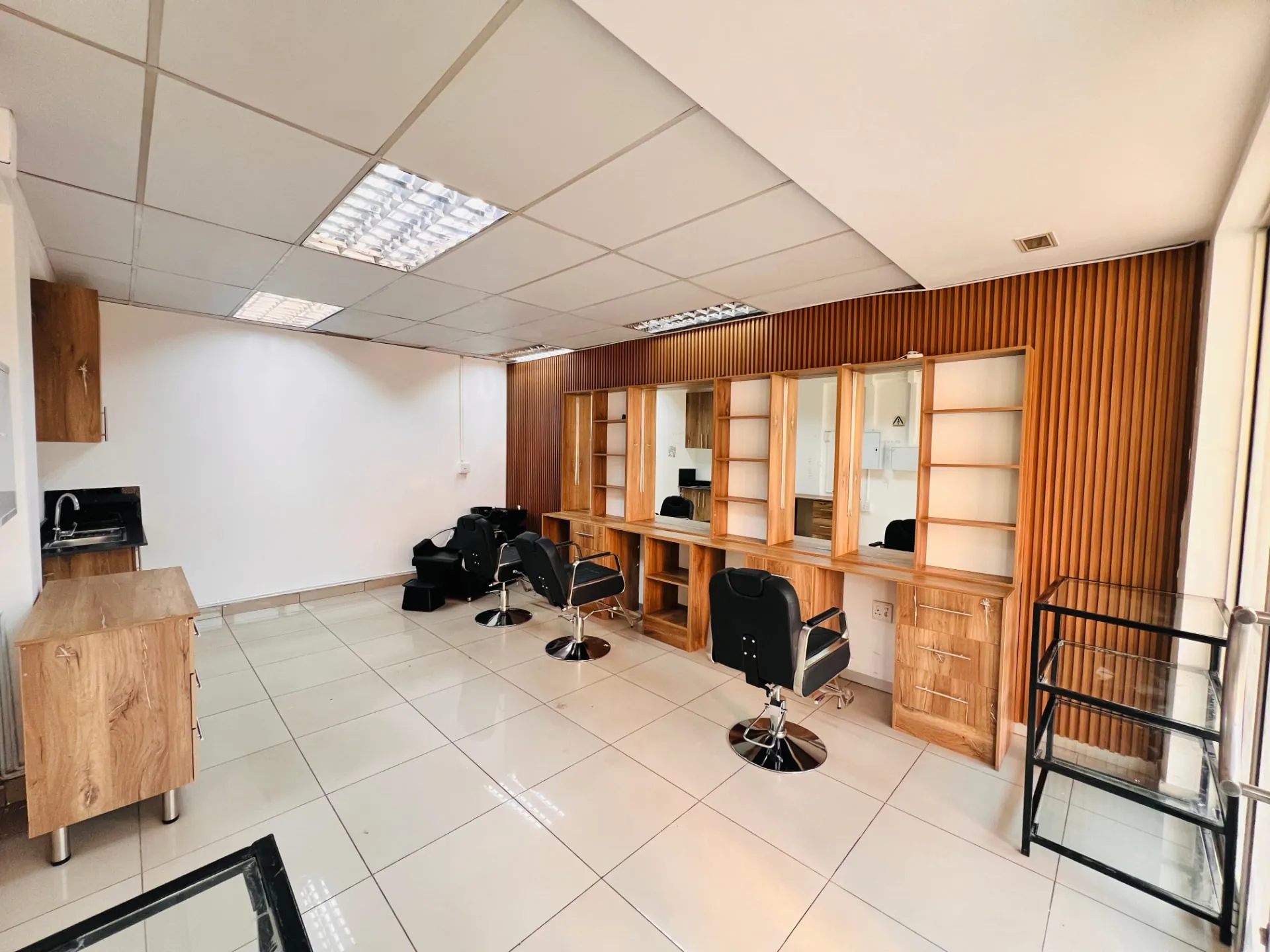 The Velvet Edge hair salon floor — LED-lit mirrors, styling chairs and warm wood panelling